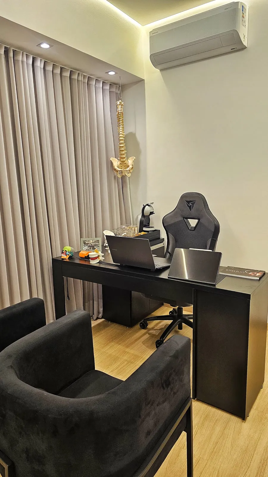 Consultório do Dr. Pedro Rosário com modelo de coluna vertebral sobre a mesa, no Instituto Perseverar